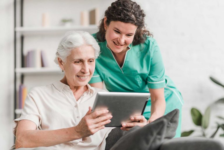 Oude dame en verpleegster met tablet